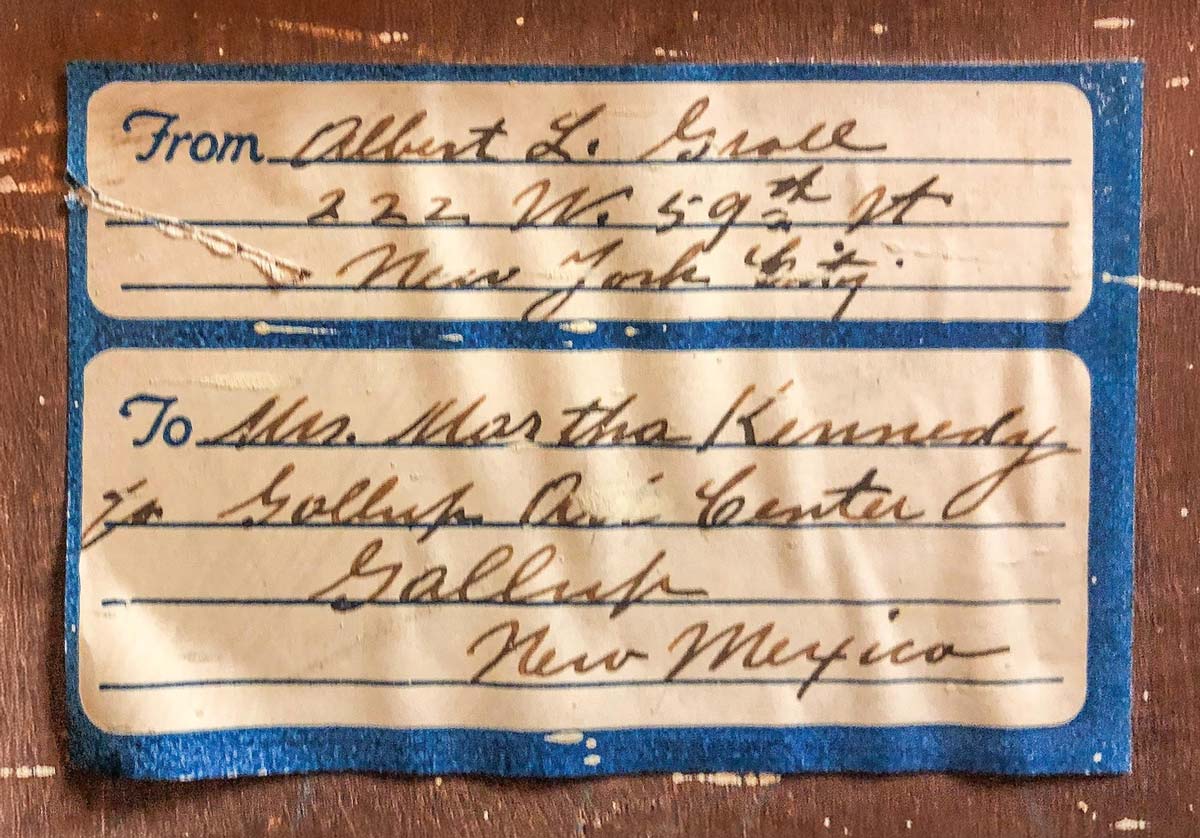 A photograph of a mailing label with "To" and "From" sections and handwritten text in brown ink. The sender's address: Albert L. Groll, 222 W. 59th St, New York City. The recipients address: Mrs. Martha Kennedy, Gallup Art Center, Gallup, New Mexico. The label has a blue border.